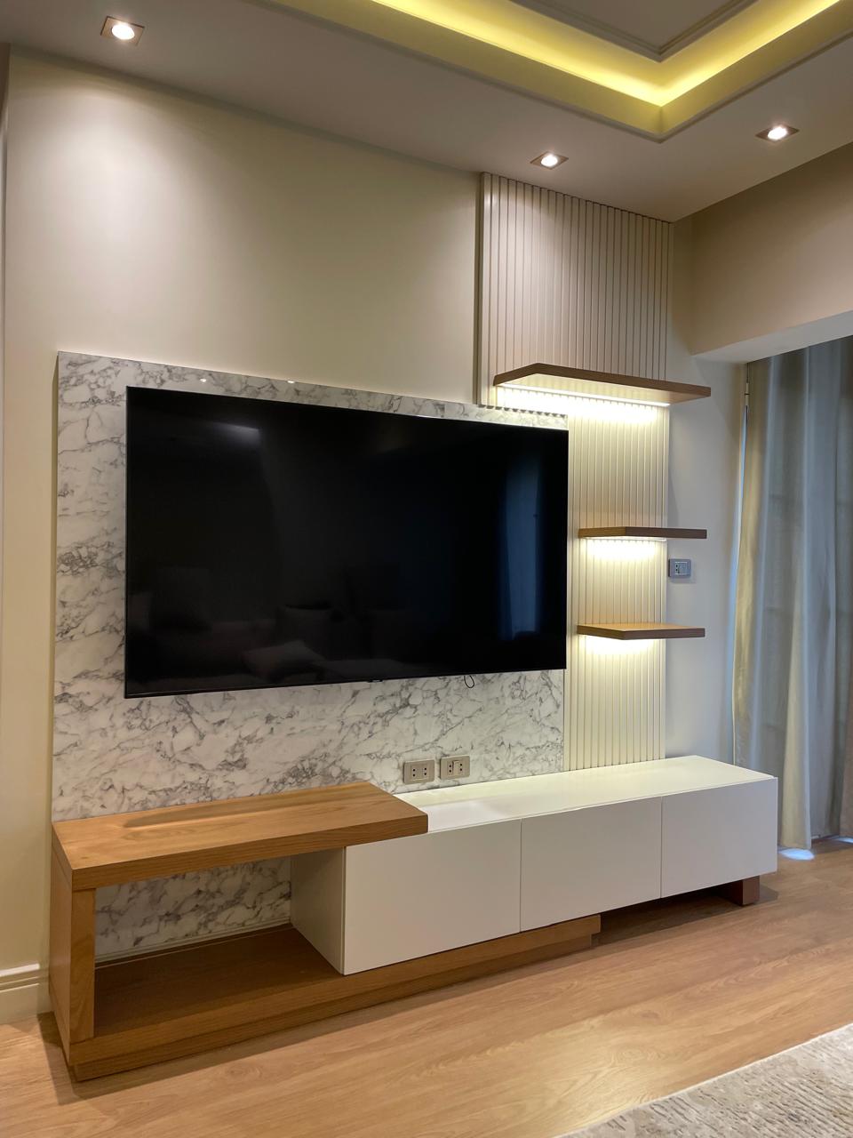 Modern living room with a television mounted on a decorative wall.