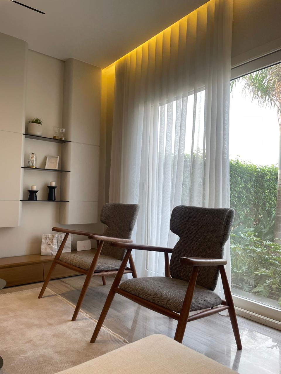 Modern living room with two chairs and a large window.