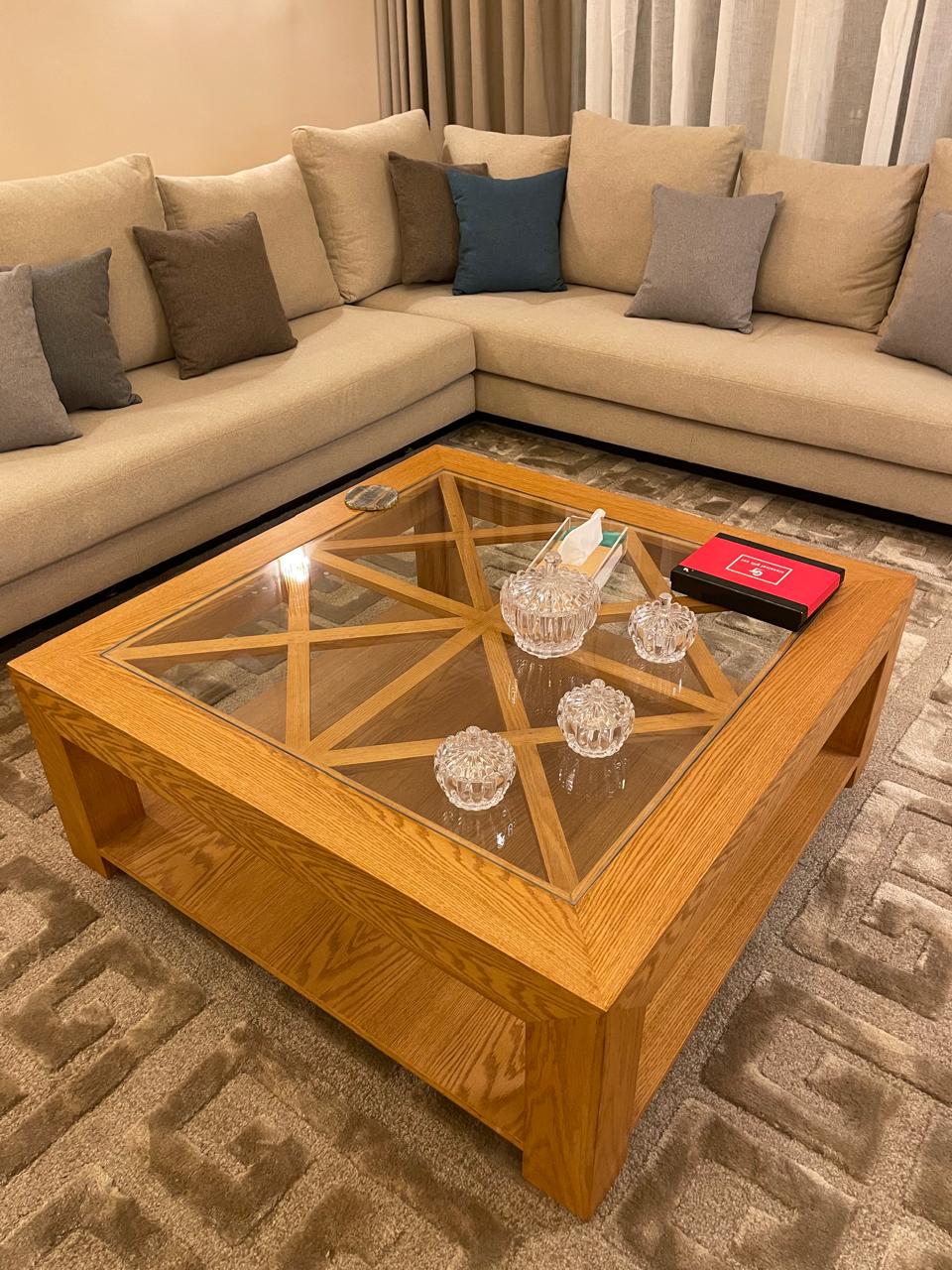 Beige sectional sofa with decorative pillows and a wooden coffee table in a living room.