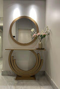 Decorative round mirror with a matching console table in a room setting.
