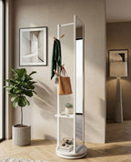 White freestanding mirror with shelves in a room with a plant and framed picture.