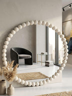 Large decorative mirror with a white bead frame in a modern interior setting.